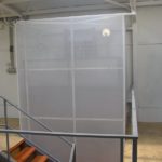 Áttetsző burkolatú teheremelő a galériaszinten, lépcső mellett